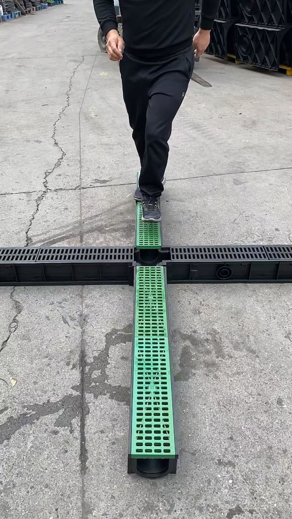 Plastic drainage grates installed across intersecting linear drainage channels